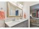 Double vanity bathroom with gray cabinets and a view into a bedroom at 1950 Marlington Way, Clearwater, FL 33763