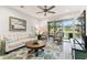 Living room with light-colored sofa and access to a balcony at 1950 Marlington Way, Clearwater, FL 33763