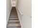 Carpeted staircase with a white handrail at 1950 Marlington Way, Clearwater, FL 33763