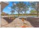 Landscaped backyard with pond view, stone pathway, and various plants at 217 Linger Ln, Sun City Center, FL 33573