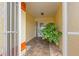 Front entrance with tiled flooring, featuring a security gate and a potted plant at 217 Linger Ln, Sun City Center, FL 33573