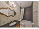 Elegant bathroom with dark vanity, patterned wallpaper, and soaking tub at 217 Oceania Ct, Apollo Beach, FL 33572