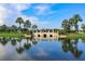 Reflective lake with stone bridge and palm trees at 217 Oceania Ct, Apollo Beach, FL 33572