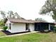 Rear view of the house showing the screened porch and landscaping at 2200 Shelly Dr # C, Palm Harbor, FL 34684