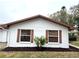 Side view showcasing the stucco exterior, brown window accents, and landscaping at 2200 Shelly Dr # C, Palm Harbor, FL 34684