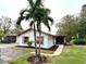 Front view of charming single story home with palm trees and well maintained landscaping at 2200 Shelly Dr # C, Palm Harbor, FL 34684