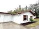 Attached garage with white stucco exterior and brown accents at 2200 Shelly Dr # C, Palm Harbor, FL 34684