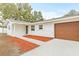 White house with a wood garage door and red mulch at 2255 S Lagoon Cir, Clearwater, FL 33765