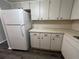 White cabinets and a large refrigerator highlight this galley-style kitchen at 2449 Columbia Dr # 55, Clearwater, FL 33763