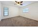 Bright bedroom with ceiling fan, carpet, and two windows at 3005 Enisglen Dr, Palm Harbor, FL 34683