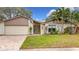 Single-story home with a white garage door and brick driveway at 3005 Enisglen Dr, Palm Harbor, FL 34683