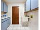 Laundry room with sink, cabinets, and tiled floor at 3005 Enisglen Dr, Palm Harbor, FL 34683