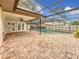 Inviting pool area with covered patio and brick pavers at 3005 Enisglen Dr, Palm Harbor, FL 34683