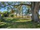 Landscaped backyard with large oak tree and green grass at 3147 Hyde Park Dr, Clearwater, FL 33761