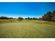 Golf course putting green with flag and pond in background at 3147 Hyde Park Dr, Clearwater, FL 33761