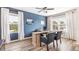 Bright home office with stylish wooden floors, light wood desk, and blue accent wall at 4644 Pleasant Ave, Palm Harbor, FL 34683