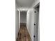 Long hallway with wood-look floors and doors to other rooms at 5211 Peach Ave, Seffner, FL 33584