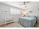 Bright bedroom with light blue bedding, wood floors, and white shutters at 5705 80Th N St # 210, St Petersburg, FL 33709