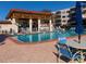 Community pool with lounge chairs, tables, and a covered patio at 5705 80Th N St # 210, St Petersburg, FL 33709