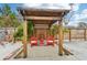 Wooden pergola with red chairs and small table at 5780 Elton Rd, Venice, FL 34293