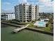 Drone view of waterfront condo building with pool and private pier at 750 Island Way # 401, Clearwater Beach, FL 33767