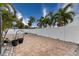 Spacious paved backyard with mature palm trees at 809 Mandalay Ave, Clearwater Beach, FL 33767