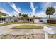 Tan house with a circular driveway and palm trees at 809 Mandalay Ave, Clearwater Beach, FL 33767