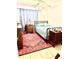 Bright bedroom with a queen bed, dresser, and area rug at 102 Cambridge Trl # 229, Sun City Center, FL 33573