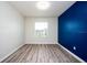 Bedroom with blue accent wall and wood-look floors at 10415 Butterfly Wing Ct, Riverview, FL 33578