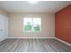 Bright bedroom featuring large window and wood-look flooring at 10415 Butterfly Wing Ct, Riverview, FL 33578