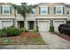 Three-unit townhome building with attached garages and landscaping at 10415 Butterfly Wing Ct, Riverview, FL 33578