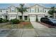 Three-unit townhome building with attached garages and landscaping at 10415 Butterfly Wing Ct, Riverview, FL 33578