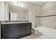 Bathroom boasts granite countertop, dark brown cabinets, and bathtub at 10825 Charmwood Dr, Riverview, FL 33569