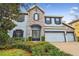 Two-story house with stone and blue siding, three-car garage, and landscaping at 10825 Charmwood Dr, Riverview, FL 33569