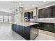 Modern kitchen with island, dark cabinets, and stainless steel appliances at 10825 Charmwood Dr, Riverview, FL 33569