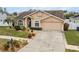 Tan one-story house with a landscaped yard at 11424 Zenith Cir, Tampa, FL 33635