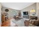 Living room with hardwood floors, brown couches and a large TV at 11424 Zenith Cir, Tampa, FL 33635