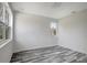 Simple bedroom with wood-look floors and a single window at 11926 Riverhills Dr, Tampa, FL 33617