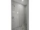 Walk-in shower with marble-look walls and mosaic tile floor at 11926 Riverhills Dr, Tampa, FL 33617