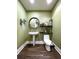 Stylish powder room with pedestal sink, toilet, and floating shelves at 130 Riviera Dunes Way # 605, Palmetto, FL 34221