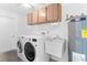 Bright laundry room, washer, dryer, cabinets, and utility sink at 13561 105Th Ave, Largo, FL 33774