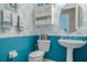 Charming teal powder room with decorative wallpaper and a pedestal sink at 16213 Diamond Bay Dr, Wimauma, FL 33598