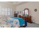 Primary bedroom with a large bed, ample dresser space, and calming blue tones at 16213 Diamond Bay Dr, Wimauma, FL 33598