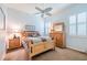 Cozy bedroom with wooden furniture, ceiling fan, and large windows at 16213 Diamond Bay Dr, Wimauma, FL 33598