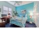 Bright bedroom with white metal bed frame, blue carpet, and desk area at 16213 Diamond Bay Dr, Wimauma, FL 33598