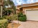 Home exterior with a three-car garage and well-maintained landscaping at 16213 Diamond Bay Dr, Wimauma, FL 33598