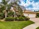 House exterior with palm trees, three car garage, and manicured lawn at 16213 Diamond Bay Dr, Wimauma, FL 33598