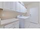 Convenient laundry room with washer, dryer, and ample cabinet storage at 16213 Diamond Bay Dr, Wimauma, FL 33598