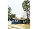 Exterior of a single-story home with dark blue siding, white trim, and a well-manicured lawn at 1701 Shore Acres Ne Blvd, St Petersburg, FL 33703