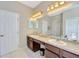 Double vanity bathroom with dark brown cabinets and tiled floors at 2104 Park Crescent Drive, Land O Lakes, FL 34639